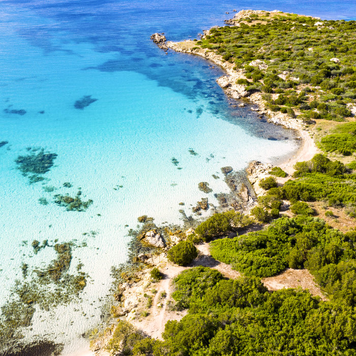 View from above, stunning aerial view of a rocky coastline bathed by a beautiful turquoise sea. Cala Sabina, Costa Smeralda, Sardinia, Italy.